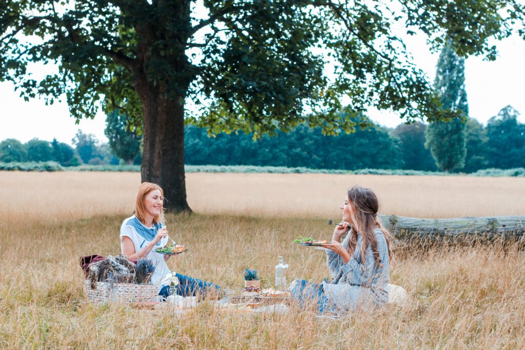 Two friends sitting in the park having a picnic