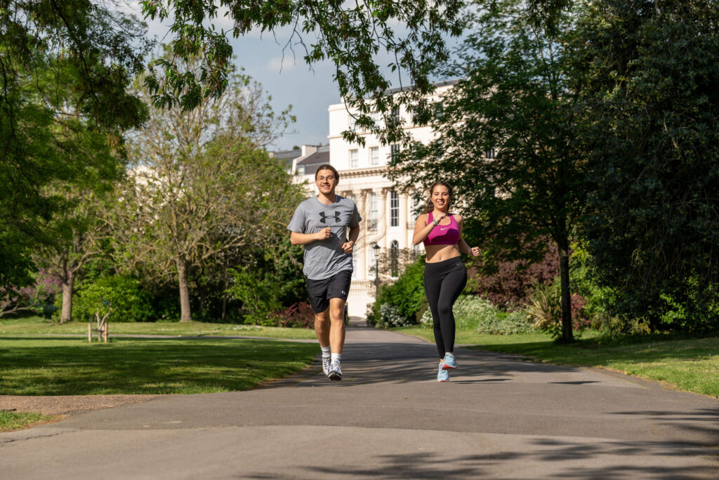 two students running in the park during exam time