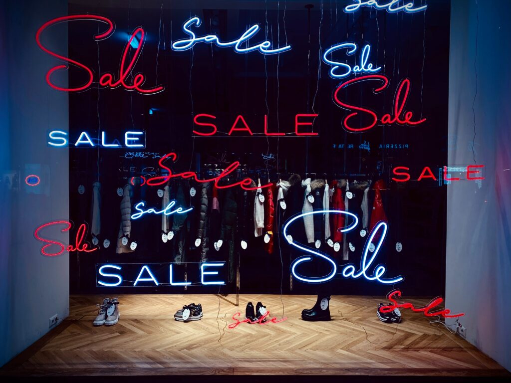 The word 'sale' written in blue and red in different fonts in a shop window 