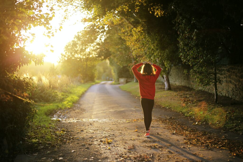 Woman walking in the park with her hands on her head 