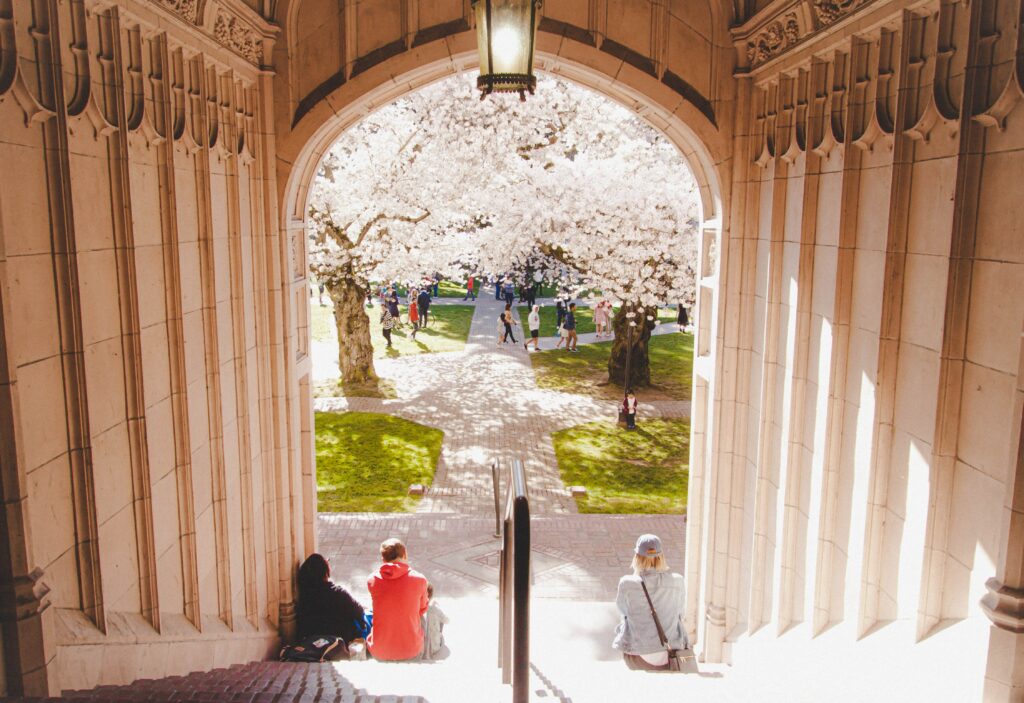 Three people sitting on the stairs at their university campus 