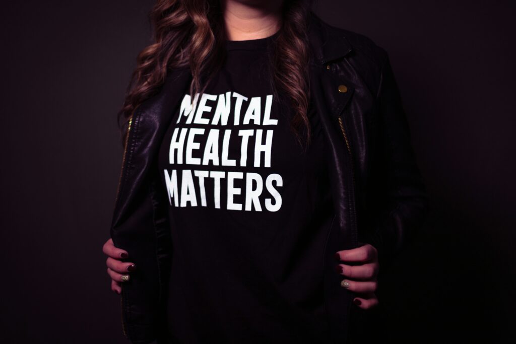 A person wearing a black top that says mental health matters 