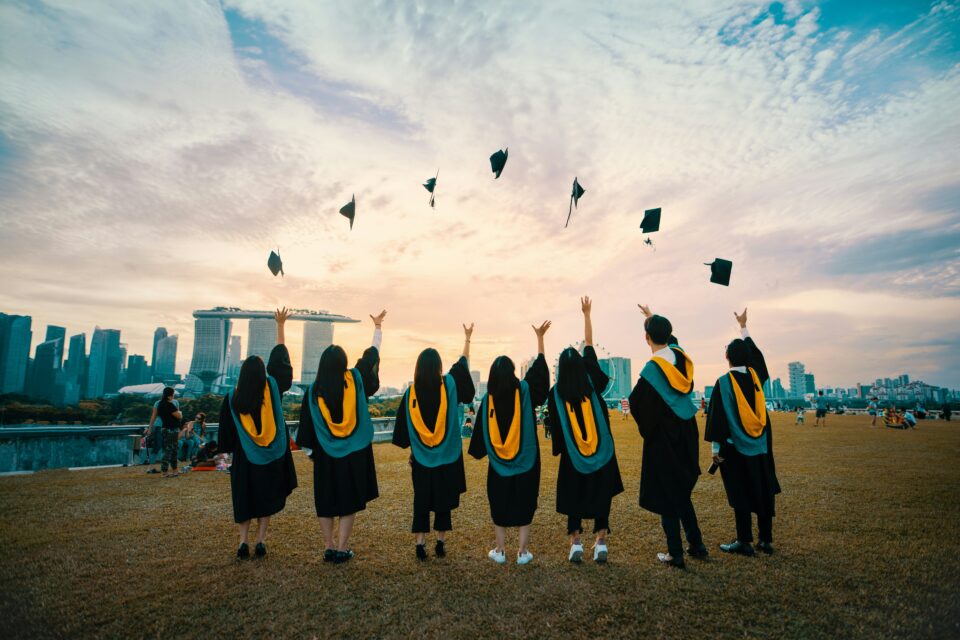 7 people throwing their graduation hats in the air