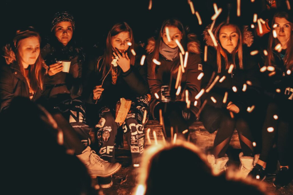 A close up shot of a group of people around a fire
