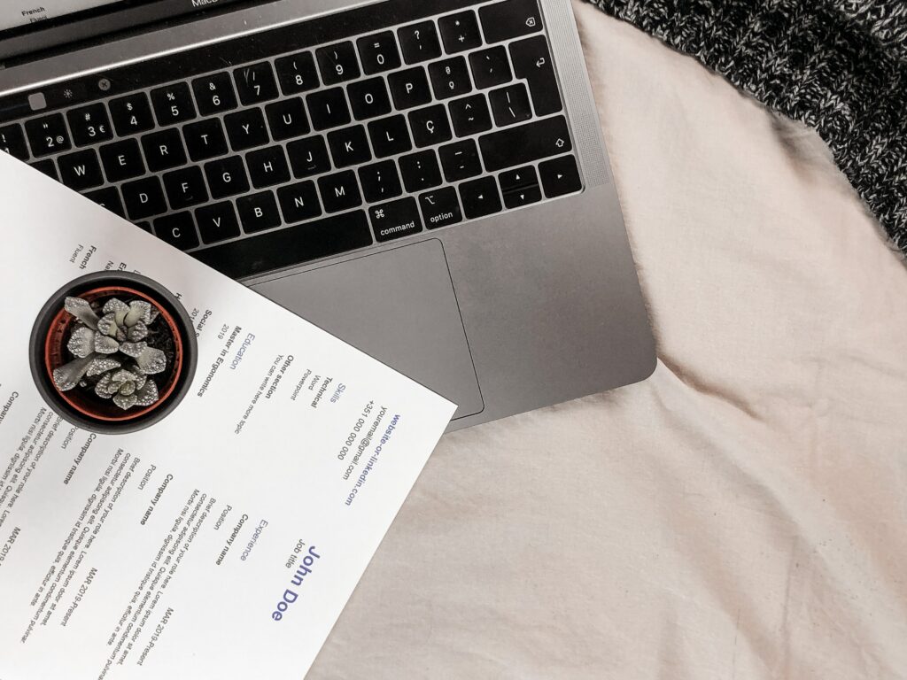 A CV on top of a Apple Mac laptop