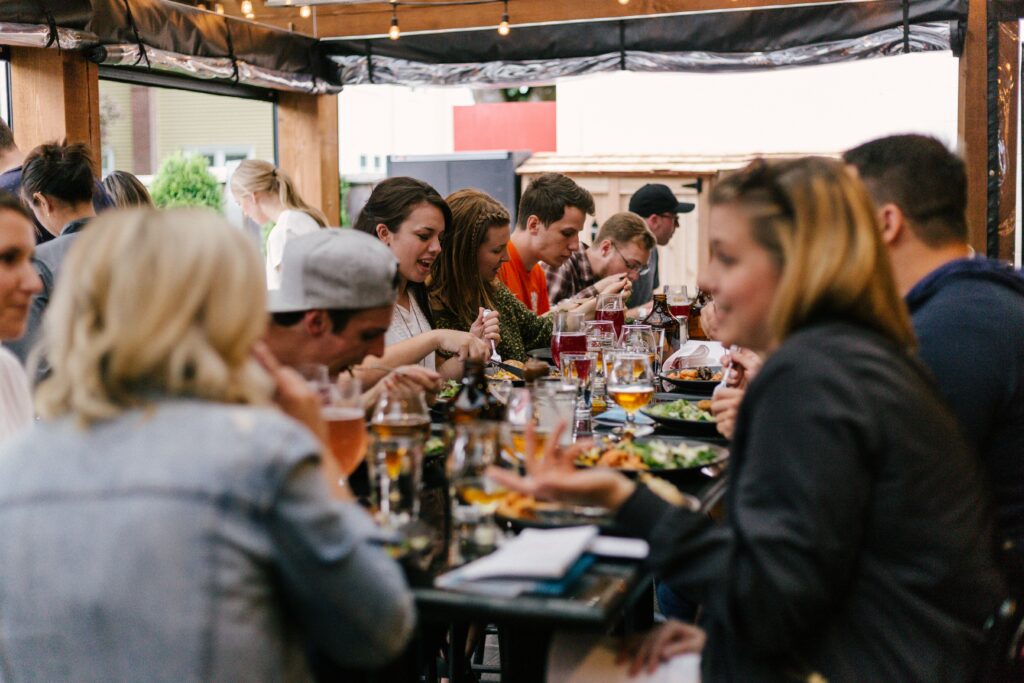 A group of people eating together in a row 