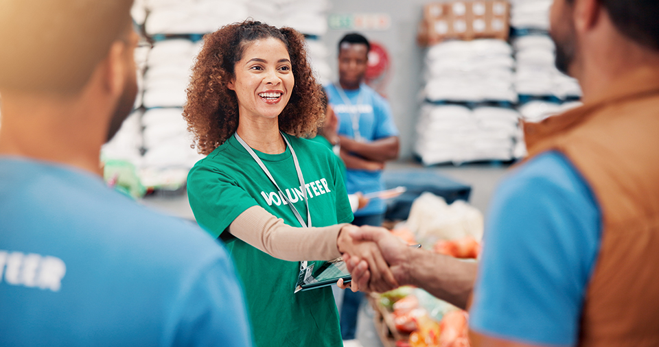 People, charity and smile for handshake, volunteering and happy to help with donations and collaboration