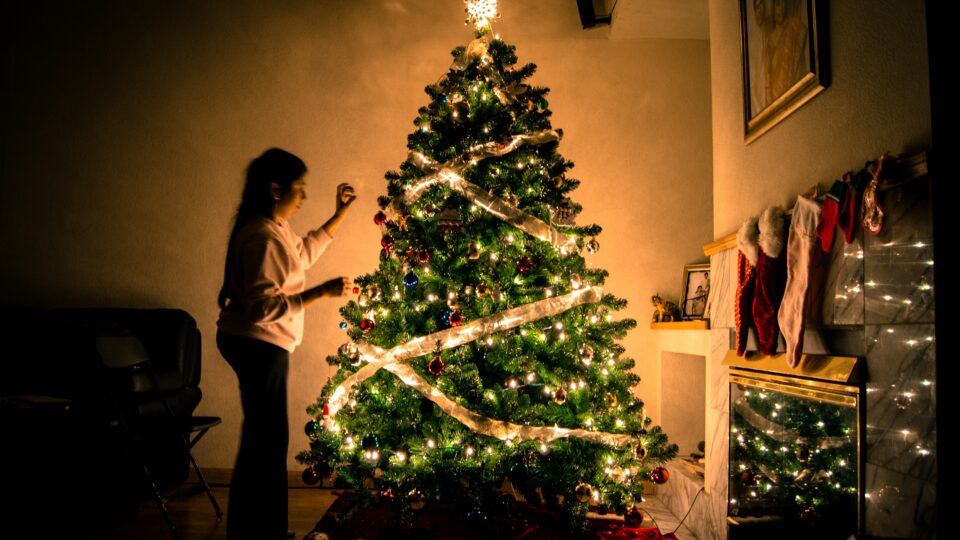 A child putting decorations on a Christmas tree