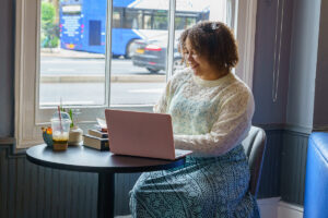 A Girl sitting down at a coffee shop with her laptop open