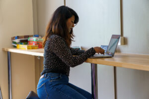 A girl sitting down with her laptop open