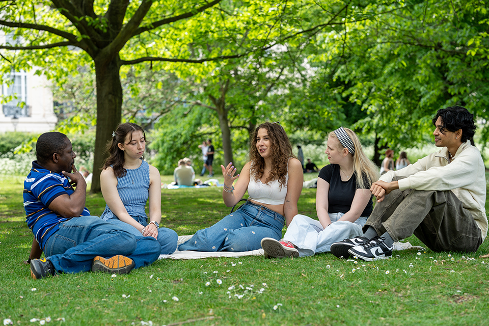 a group of international students talking in regents park, possibly about job hunting