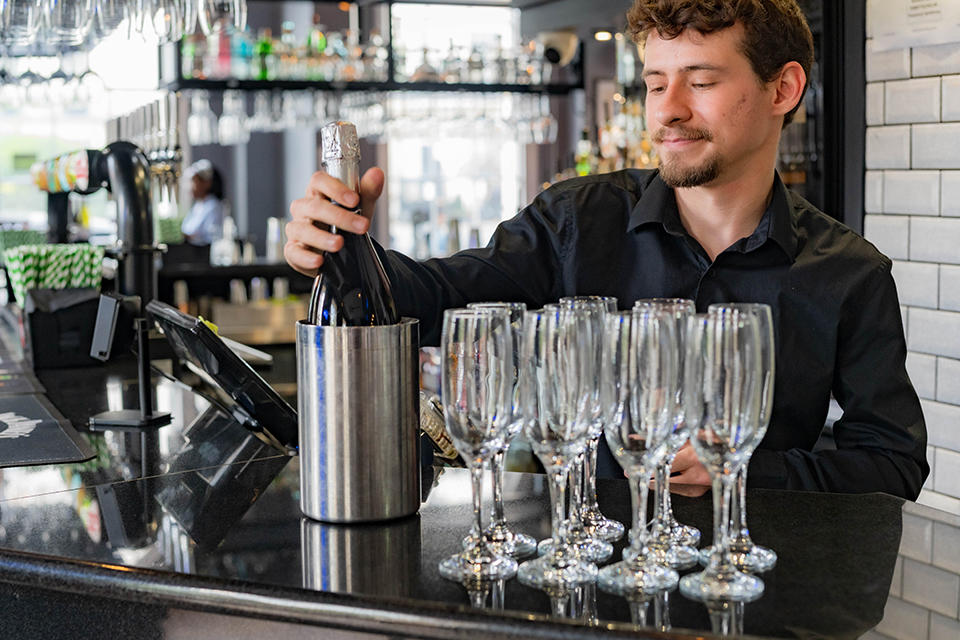 An international student part-time working as a bartender at The Thirsty Scholar. Bartending job.