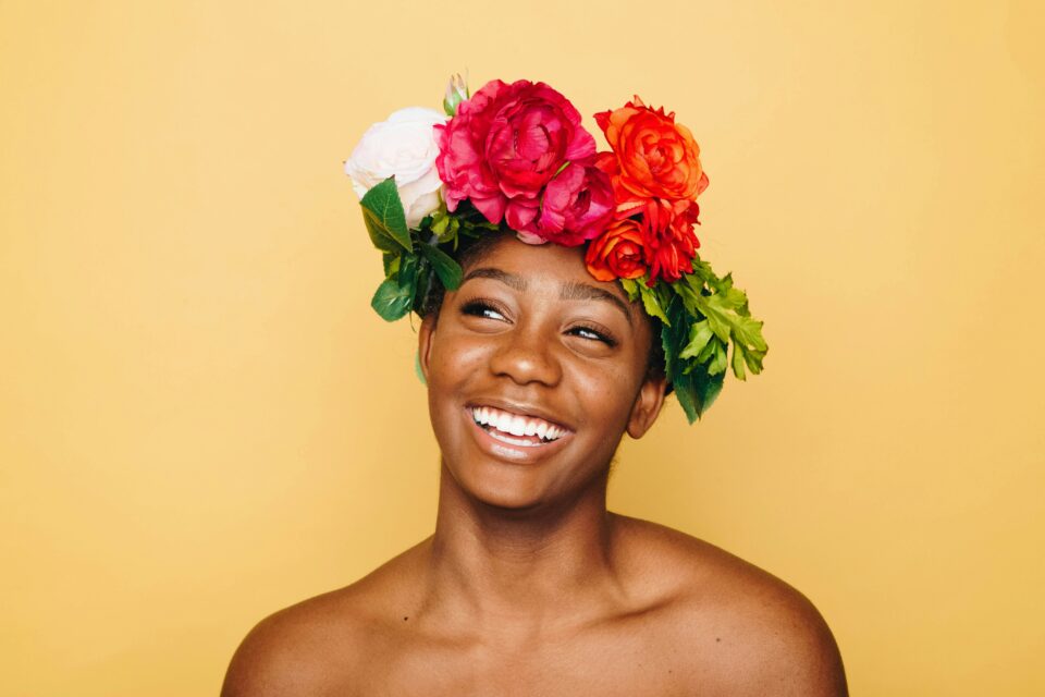 A black woman smiling with a crown of flowers on her head