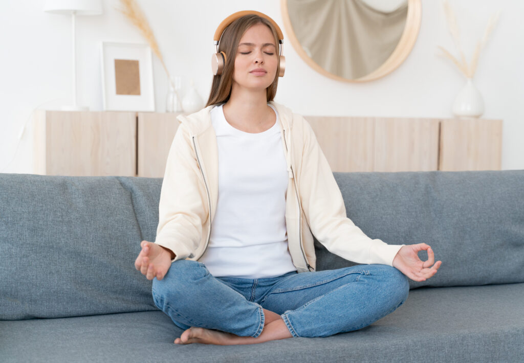 Woman sitting on couch, practicing meditation.