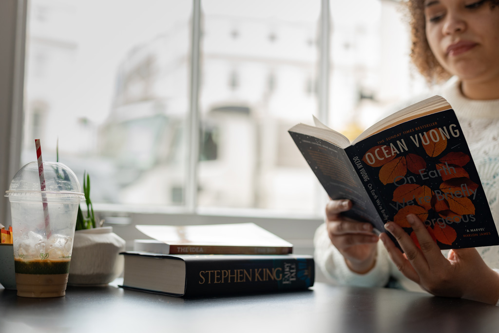 Student reading a book in a coffee shop