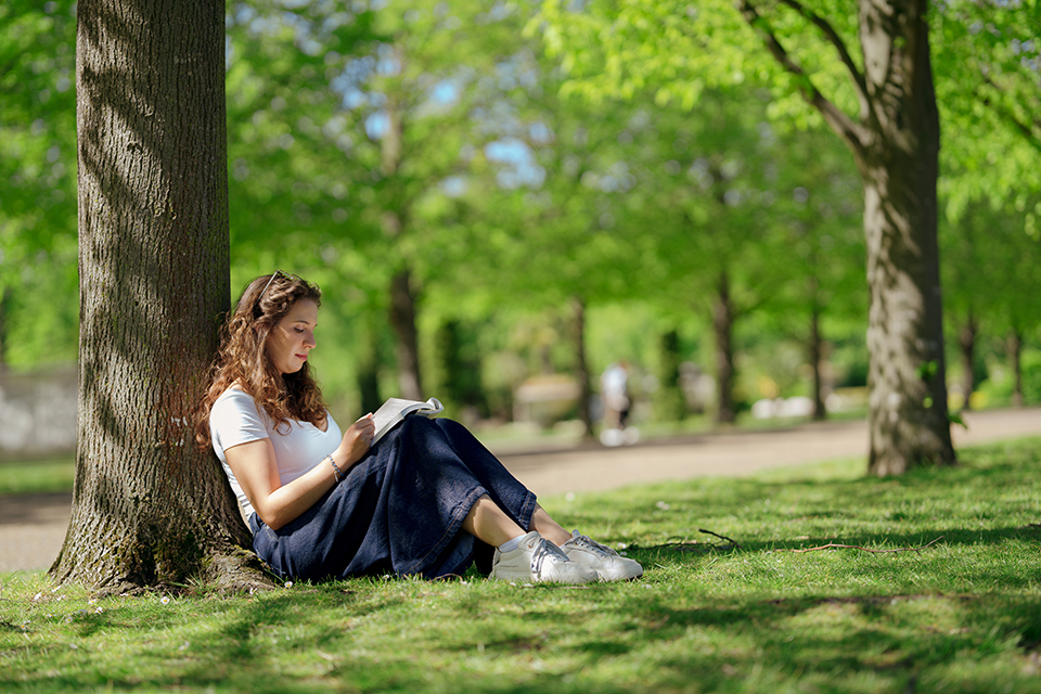 international student reading in the park