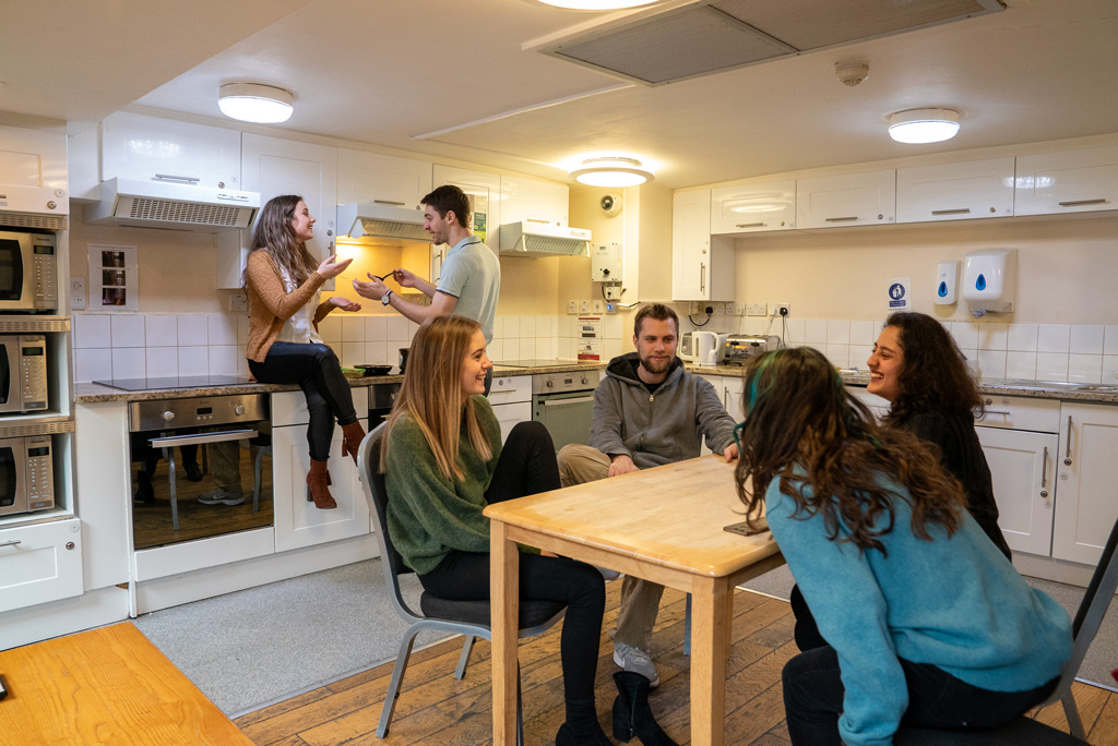 Students cooking and socialising in kitchen