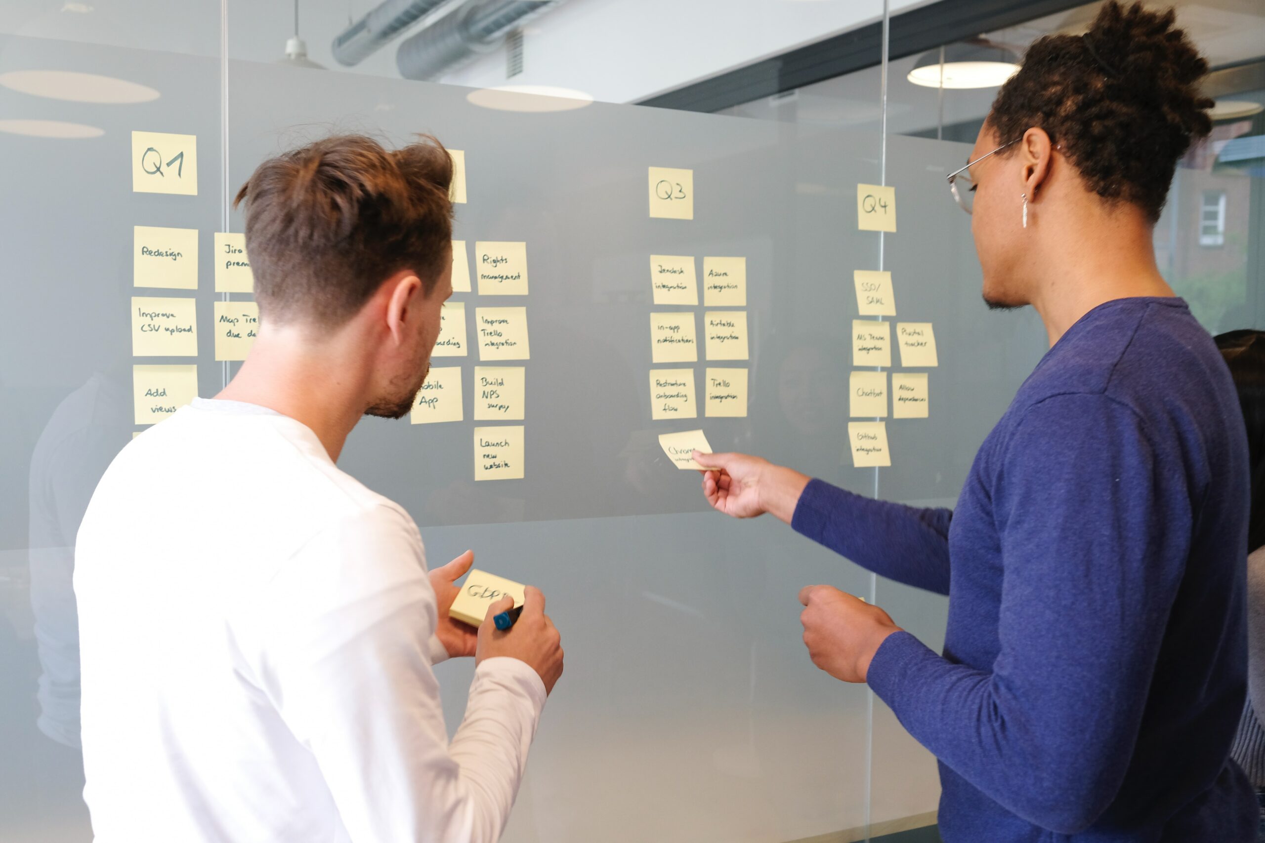 Two men putting post stick notes on the window