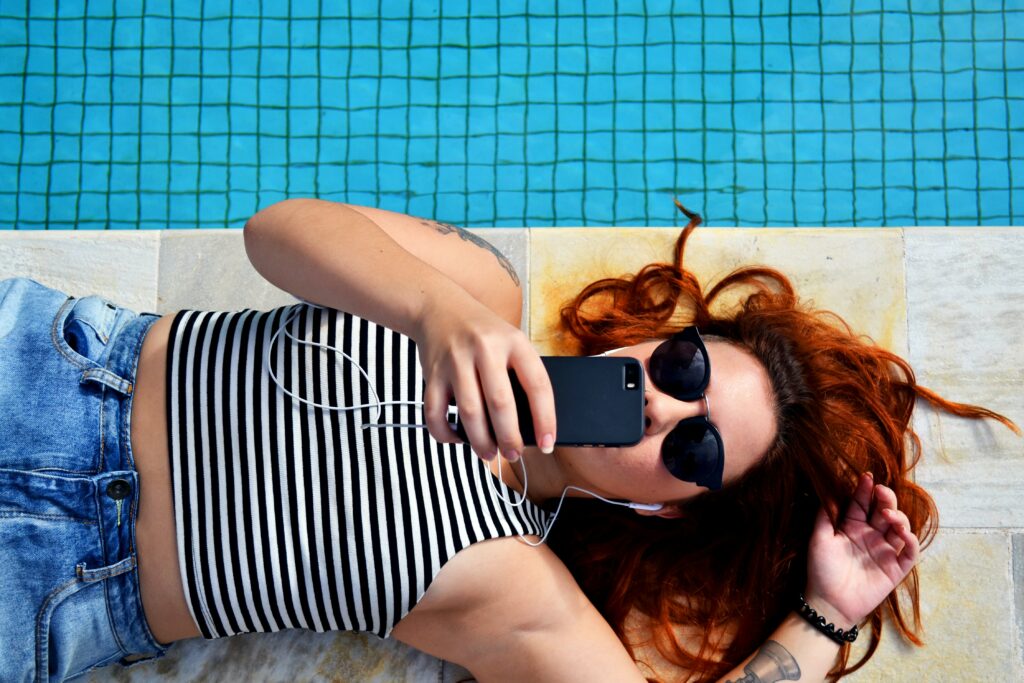 A woman listening to music near the pool