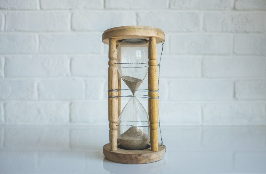A sand timer with wood around it 