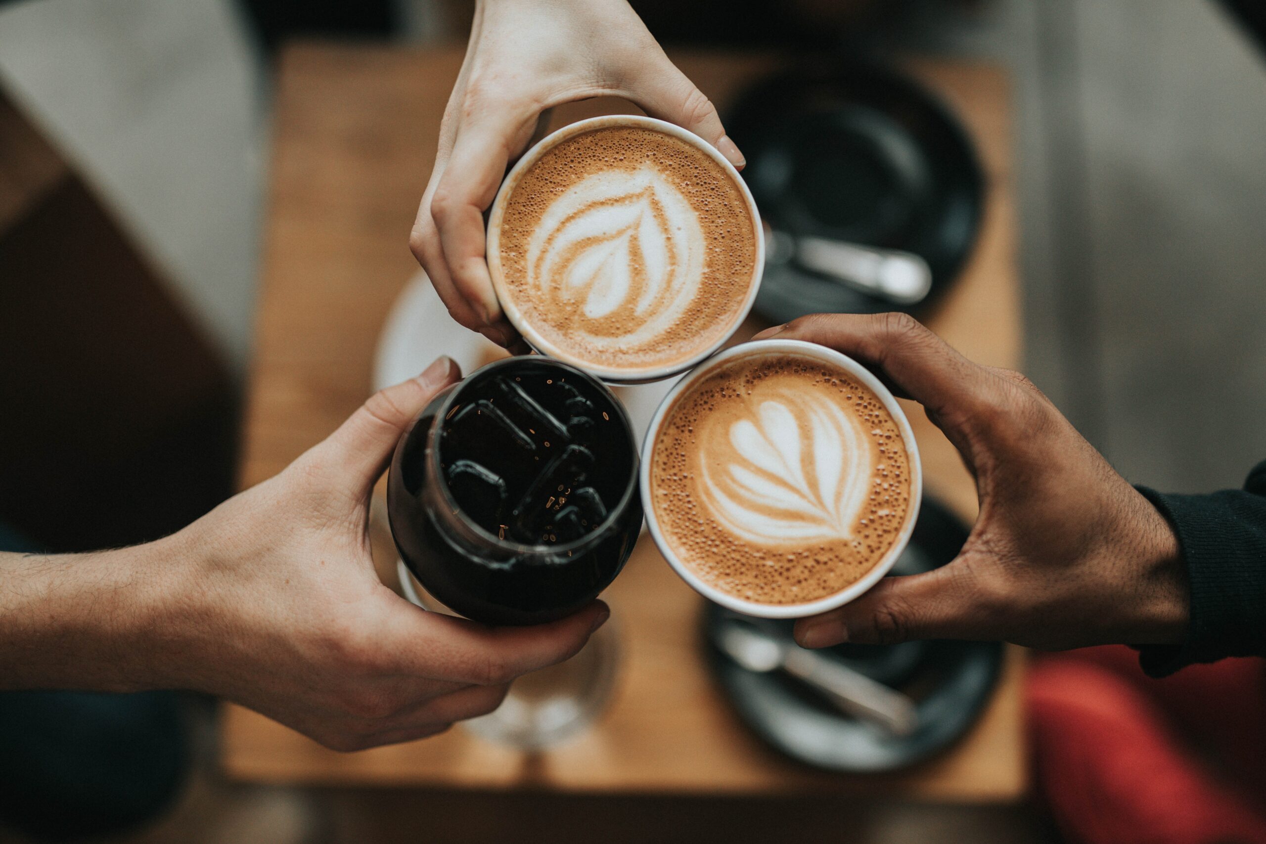 Three people putting their coffee's together