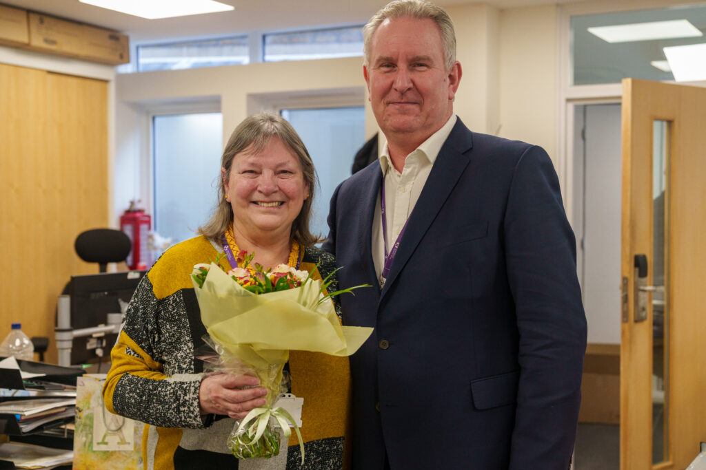 A picture of Martin and Jilly holding flowers for working 30 years at ISH 