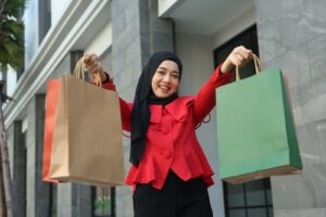 A woman holding two bags and showing the camera