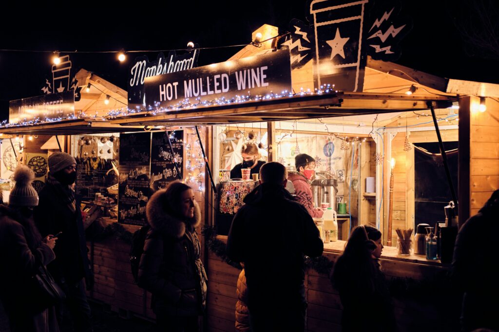 A group of people at a mulled wine stall at the Christmas market 