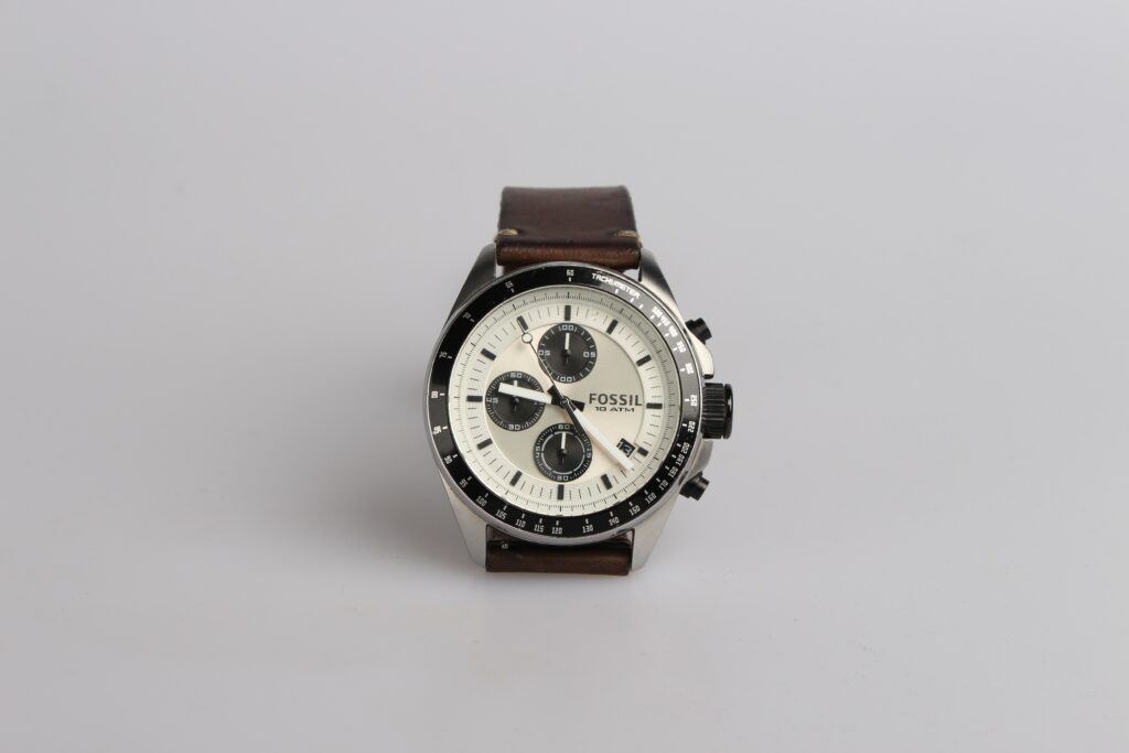 A picture of a brown watch in front of a white background 