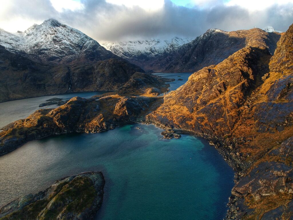 A sky view picture of the Isle of Skye with water running through the mountains