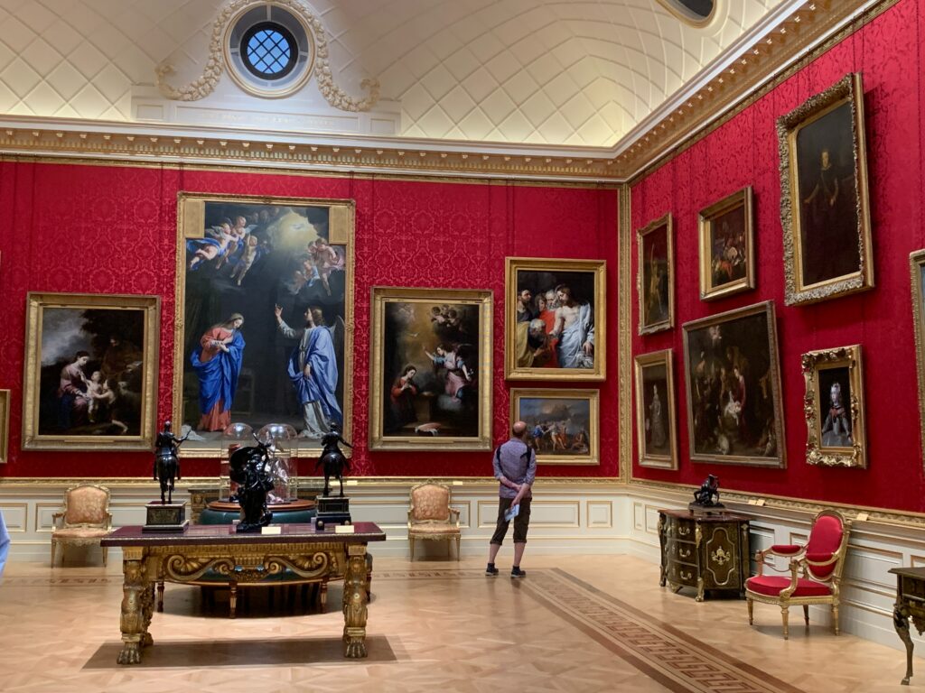 A man looking at a painting on the wall in the corner