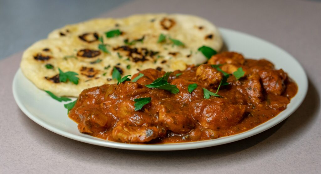 A plate of chicken curry with naan bread