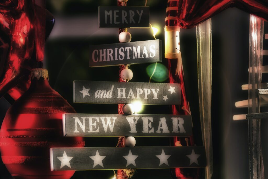 A merry Christmas and happy new year sign with red ribbon around it 