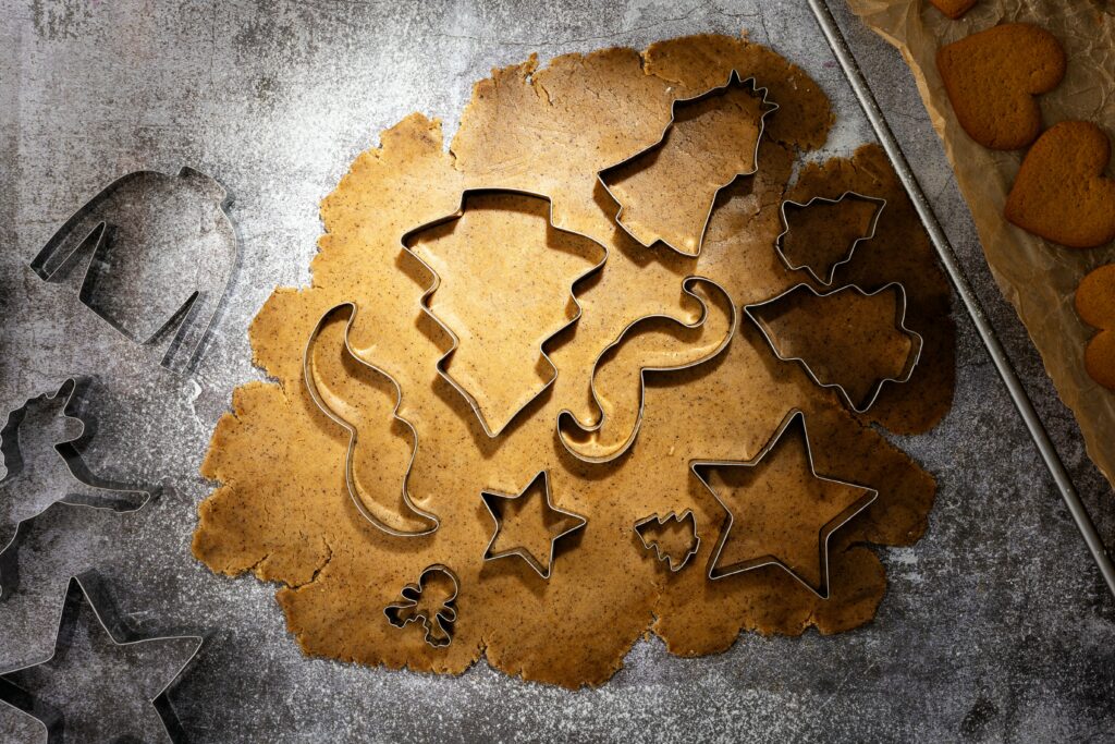 Different shapes of cookie cutters inside cookie dough 