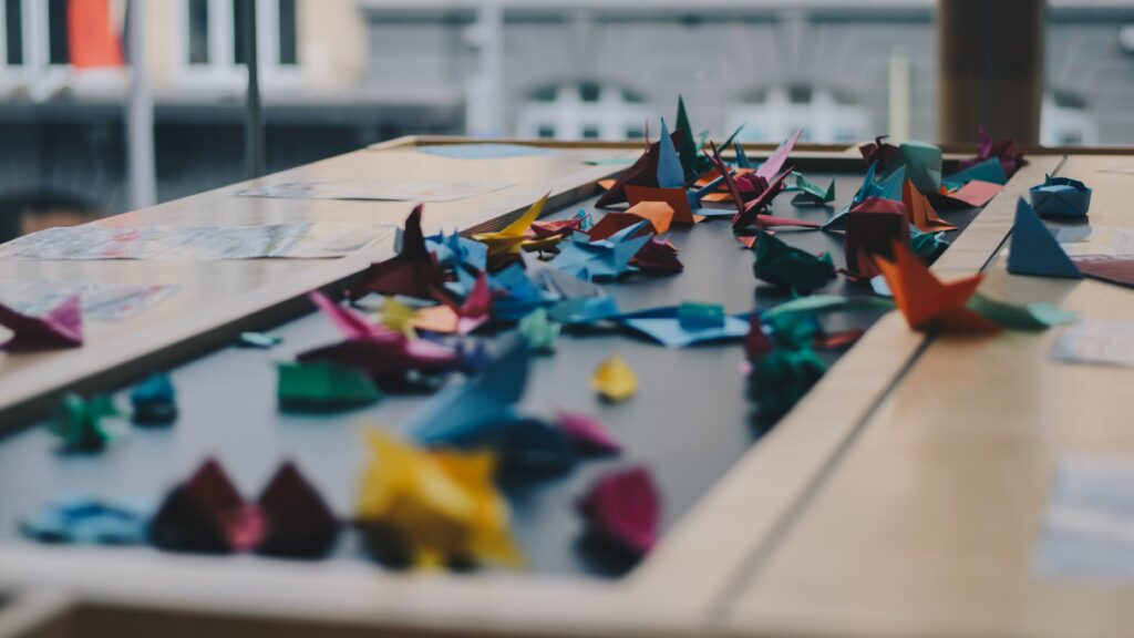 Many paper crafts on a table with different colours 