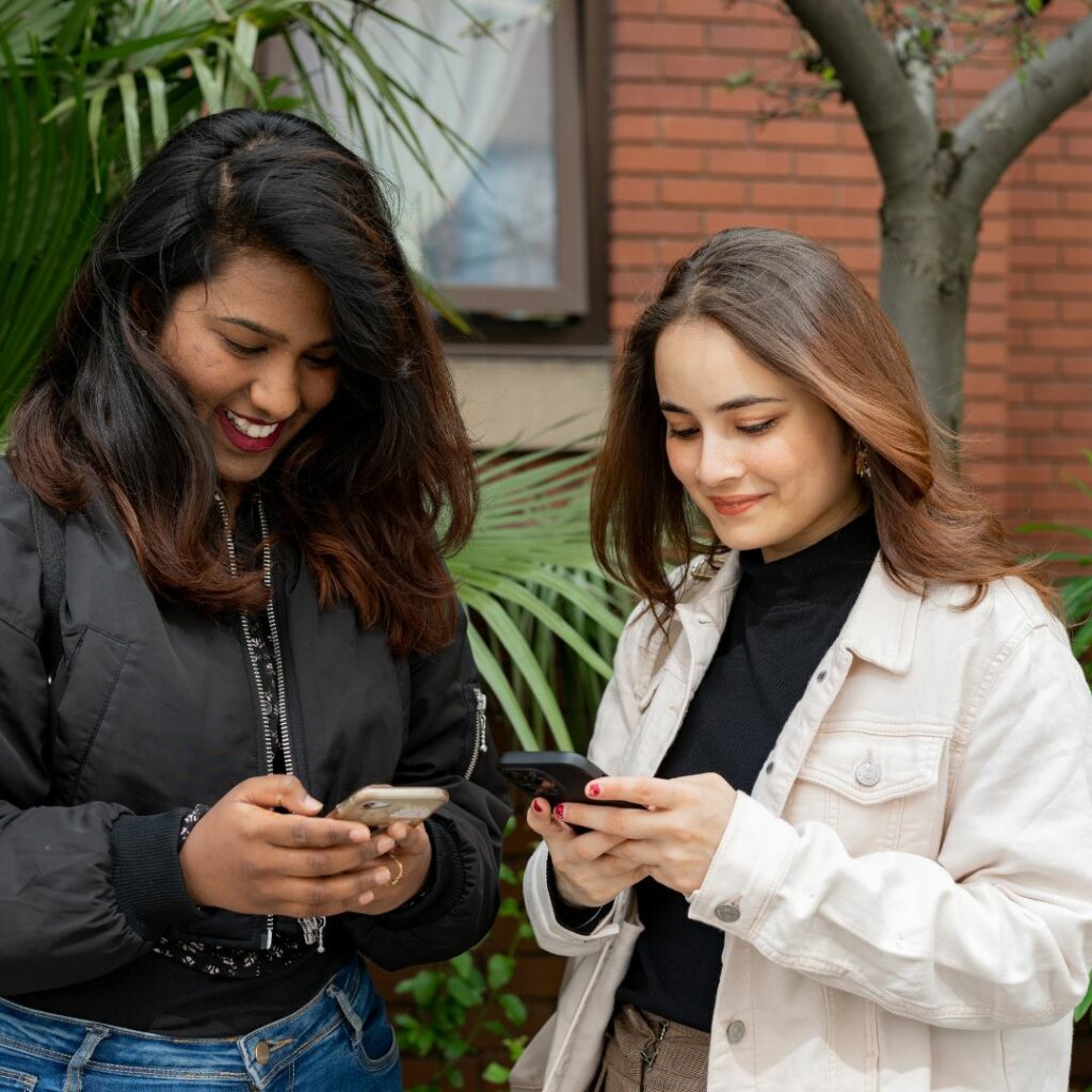 Two girls holding their phones