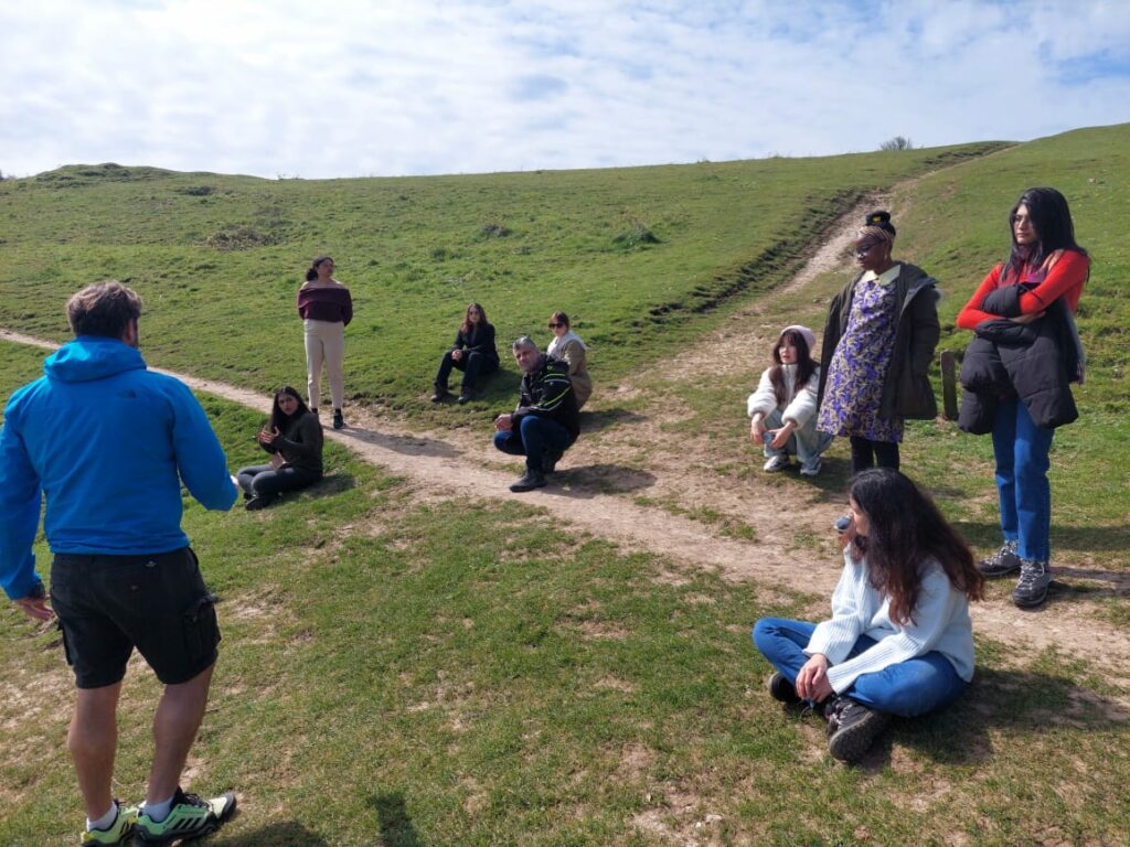 A group of people on sitting on a hill.