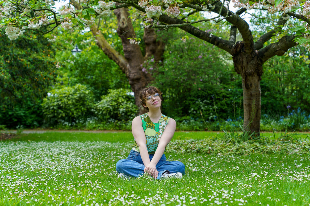 A girl sitting outside on the grass 