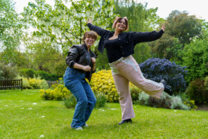 Two people smiling and posing for the camera outside