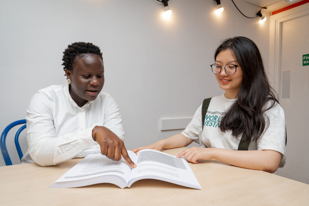 Two girls reading from a book 