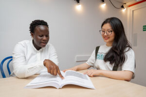 Two girls reading from a book