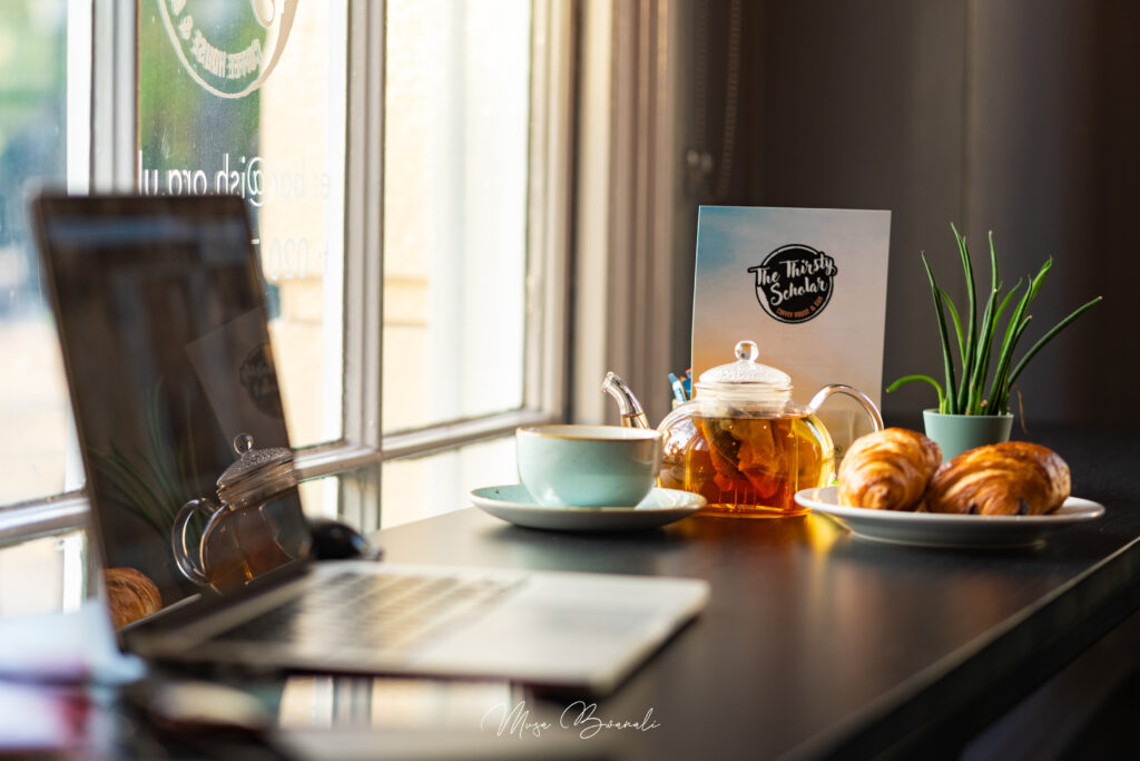 A picture of a laptop open with food next to it. 