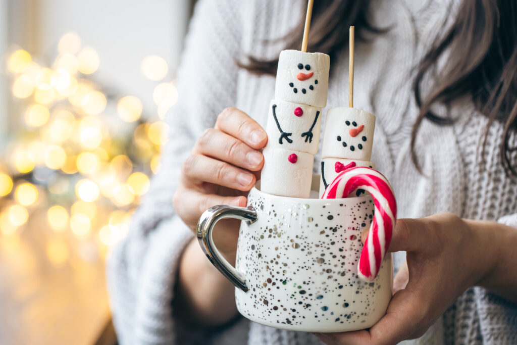 Mug Christmas Gift – International Students House – international students house cup of hot drink with marshmallow snowmen and candy in female hands