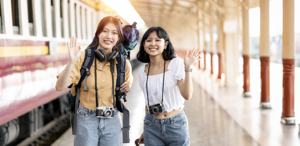 Two young female traveler on the train station, Travel lifestyle and seasonal vacation concept.