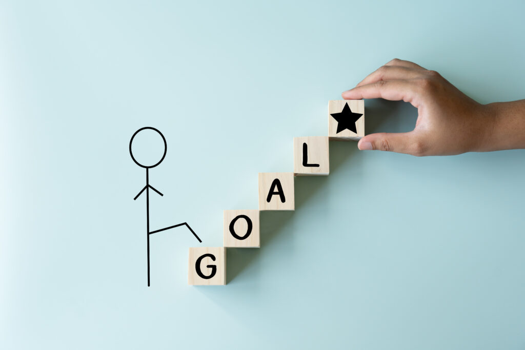 A man climbing to his goal of achievement, wooden blocks as stairs to the star the top prize of life. Target of one person on process.