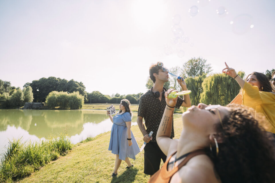 Group of friends blowing bubbles in park