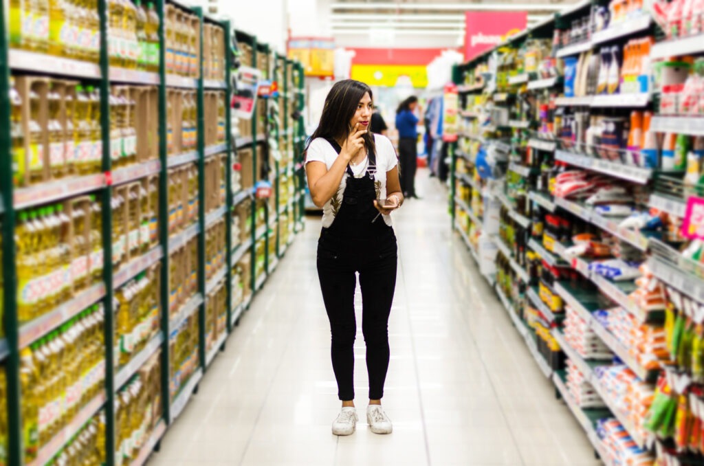 A young female Latina student looking around a supermarket