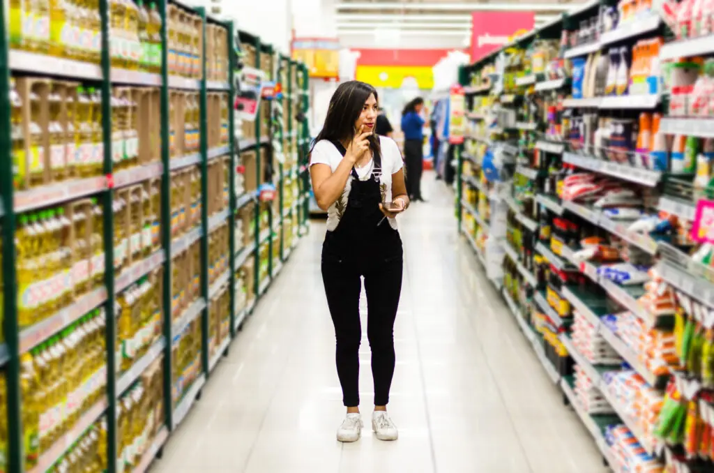 A young female Latina student looking around a supermarket