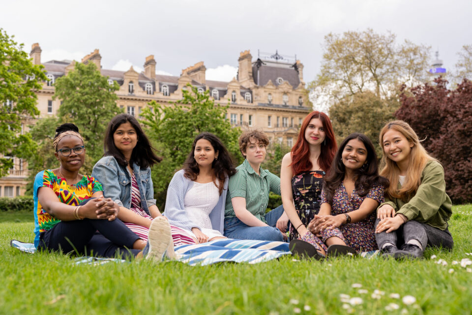 – international students house group of students sitting in the park